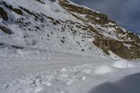 the shadow of a person standing on a snow covered slope near a mountain peak, in the background are a deep pile of snow