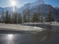 the mountain range is covered with snow and has many small amounts of ice that are melting down on the pavement