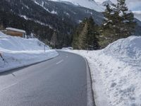 a snowy mountain is in the background on a highway with snow and evergreens lining it