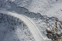 a person is skiing down the snow covered hill with his skis on the ground