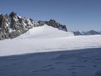 two snow skiers cross the top of a snow covered mountain pass in a white landscape