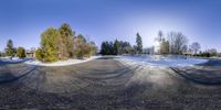 a fisheye lens view of a landscaped park, snow and trees in the foreground