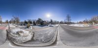 an upside down image shows a snow covered parking lot and a road at the bottom of a small hill