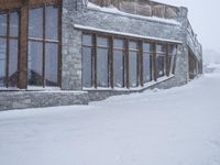 an outdoor dining restaurant covered in snow at wintertime with people walking around the building