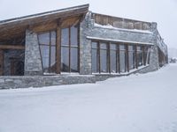 an outdoor dining restaurant covered in snow at wintertime with people walking around the building