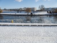 a fire hydrant near the edge of a river covered in snow next to a dock