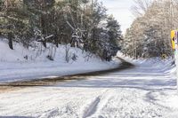 there is a snow covered road with skis parked on it in the woods in the winter