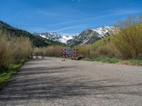 an open gate sits behind a warning sign on the side of the road that's blocked off