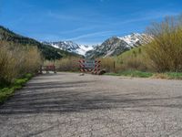 an open gate sits behind a warning sign on the side of the road that's blocked off