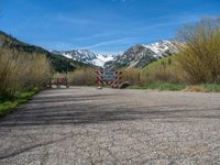 an open gate sits behind a warning sign on the side of the road that's blocked off