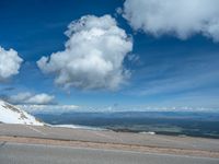 the man is at the top of a mountain on skis with mountains in the background