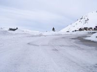 a long road that is covered in snow and some people are on the side of it