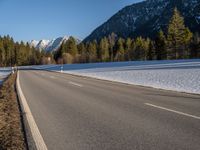 a highway next to the mountain that has snow on top of it and is closed