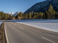 a highway next to the mountain that has snow on top of it and is closed