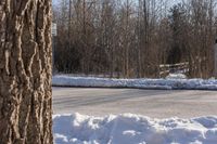 a snow covered road with a parking sign on it in a residential area in winter