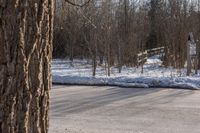 a snow covered road with a parking sign on it in a residential area in winter