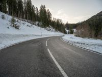 a car is parked on an open road surrounded by trees and snow covered hills a few km north