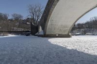 an old, snow covered road passes under a stone arch bridge in the snow in this image