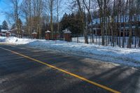 a residential driveway with snow on the ground and a stop sign that is red for winter