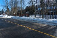 a residential driveway with snow on the ground and a stop sign that is red for winter