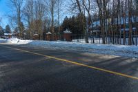 a residential driveway with snow on the ground and a stop sign that is red for winter