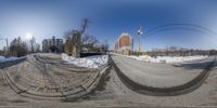 a panorama photo of a snow covered road in wintertime with the view from below