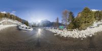 a 360 - view panoramic photo of snow covered roads with a green sign on the right