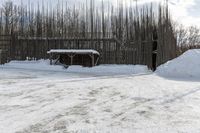 snow is piled on a road next to a small shed on a mountain road in a forested area