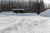 snow is piled on a road next to a small shed on a mountain road in a forested area