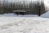 snow is piled on a road next to a small shed on a mountain road in a forested area