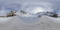 a skateboard ramp near the mountains covered in snow, on a cloudy day in europe