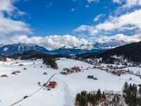 snow covered ski resort in the swiss alps near zurich, switzerland in winter time with mountains, trees and a village in the distance