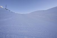 a person riding skis on top of a snow covered slope in the mountains behind him