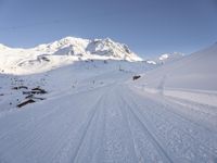 skier making its way down a snow covered slope with the surrounding mountains in the background