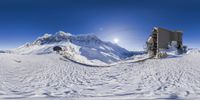 a snow covered slope with a ski lift on top of it near a mountain in the background