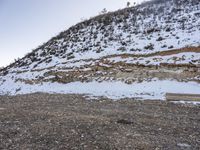 a bench in the middle of the snow covered slope near a mountain top, covered in ice