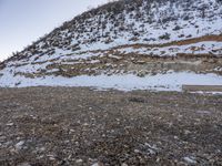 a bench in the middle of the snow covered slope near a mountain top, covered in ice