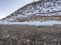 a bench in the middle of the snow covered slope near a mountain top, covered in ice