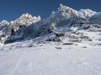 a couple of people that are walking across a snow covered slope in the snow on skis