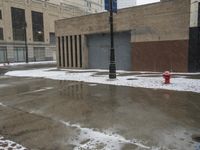 a street pole sitting on top of snow covered ground near tall buildings in the city
