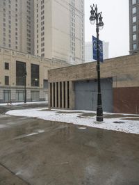 a street pole sitting on top of snow covered ground near tall buildings in the city
