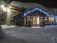 a snow covered street with light posts and snow piles in front of a house at night