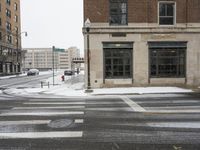 there is snow on the street and an intersection in the street is white in color