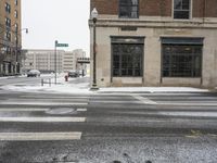 there is snow on the street and an intersection in the street is white in color