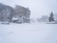 snow covered streets with cars and apartment buildings in the background in this blizzard scene photo