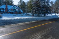 the house on the road has been partially submerged in snow and ice on it's side