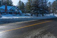 the house on the road has been partially submerged in snow and ice on it's side