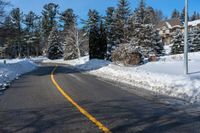 a street that has been covered in snow with yellow lines and yellow lines along the end of the road