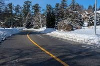 a street that has been covered in snow with yellow lines and yellow lines along the end of the road