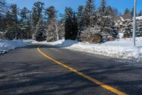 a street that has been covered in snow with yellow lines and yellow lines along the end of the road